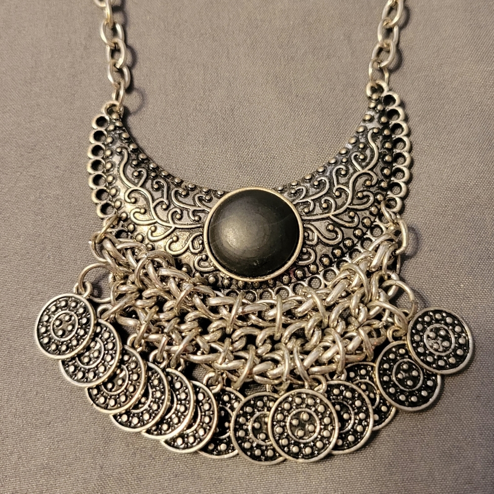 Silver necklace with black color stone with coins dangling on edge of half moon
